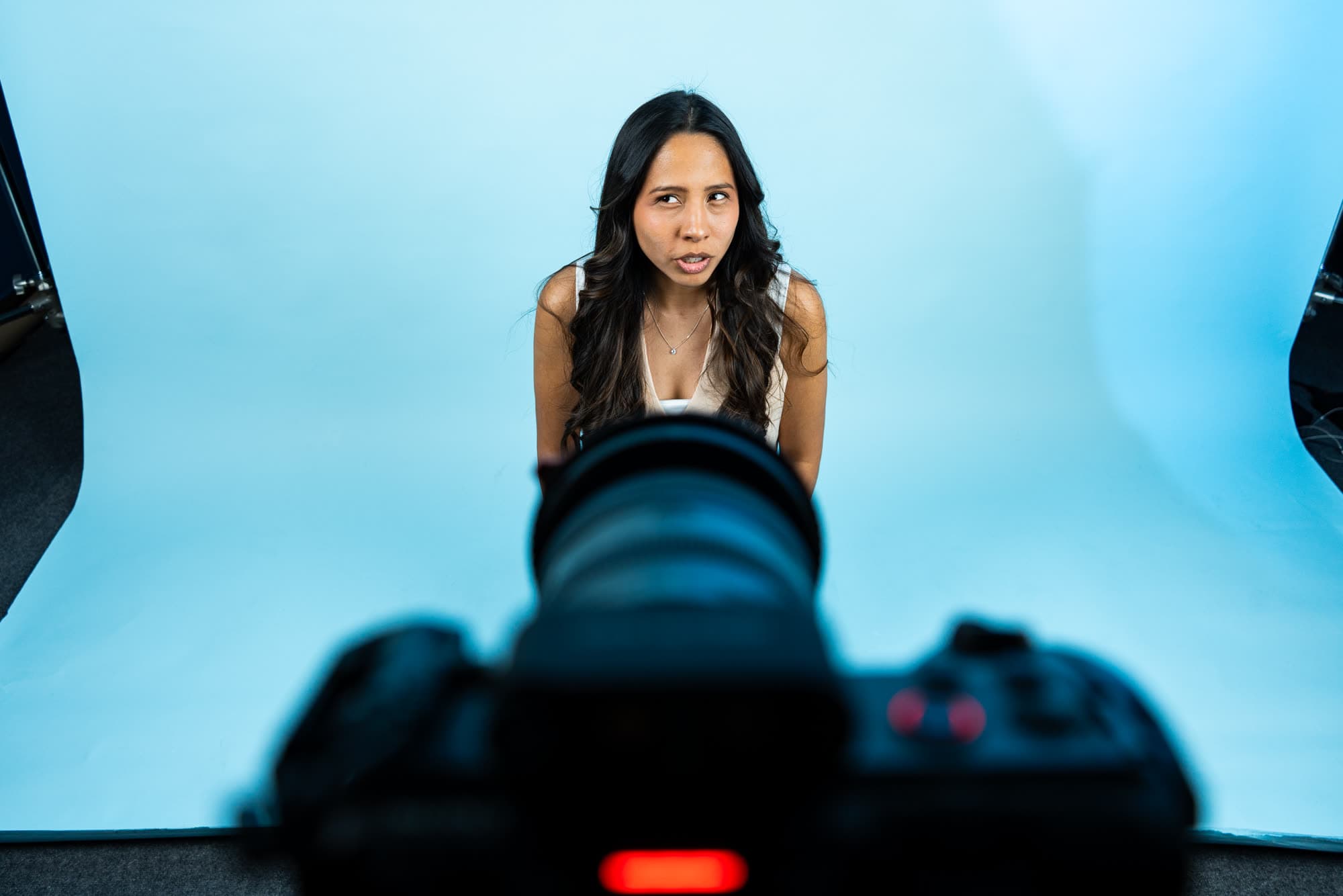 A model on a sky-blue backdrop, seen past the camera
